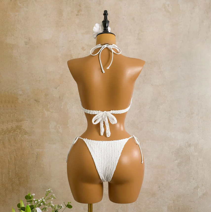 Back view of the ivory Milano Set bikini on mannequin, showing halter tie top, back tie closure and matching tie-side bottoms.