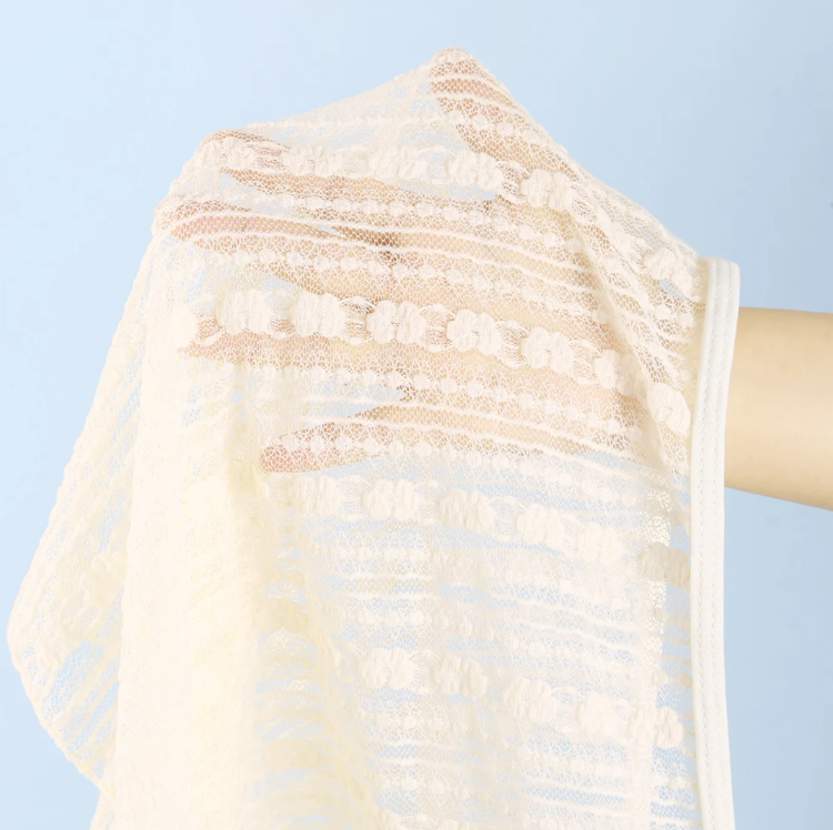 Close-up of Amalfi cream sheer mini skirt fabric with raised floral texture and soft openwork finish.