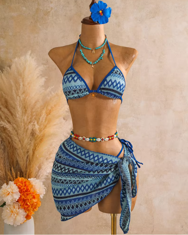 Azure blue textured triangle bikini and matching wrap sarong set displayed on mannequin with coastal resort styling.