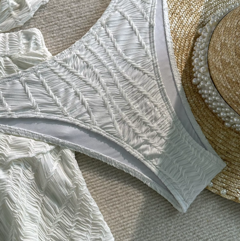 Close-up of white textured Barbados bikini bottoms with matching tiered mini skirt and raised chevron texture.