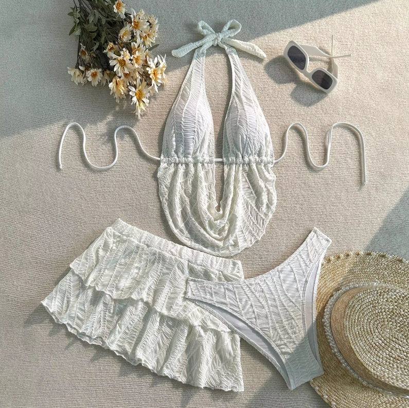 White textured Barbados bikini set with draped halter top, matching tiered mini skirt and high-leg bottoms.
