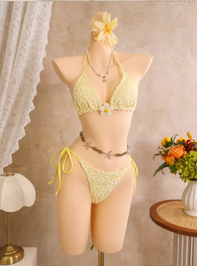 Daffodil floral embroidered triangle bikini set with flower centre accent and tie-side high-leg bottoms on mannequin.