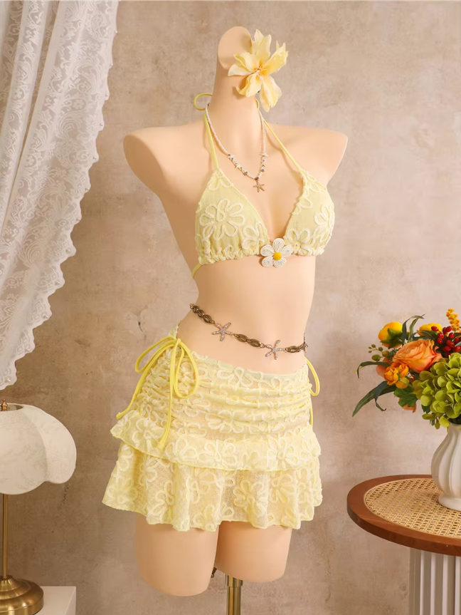 Angled front view of daffodil floral bikini and matching sheer tiered mini skirt with side-tie detailing.
