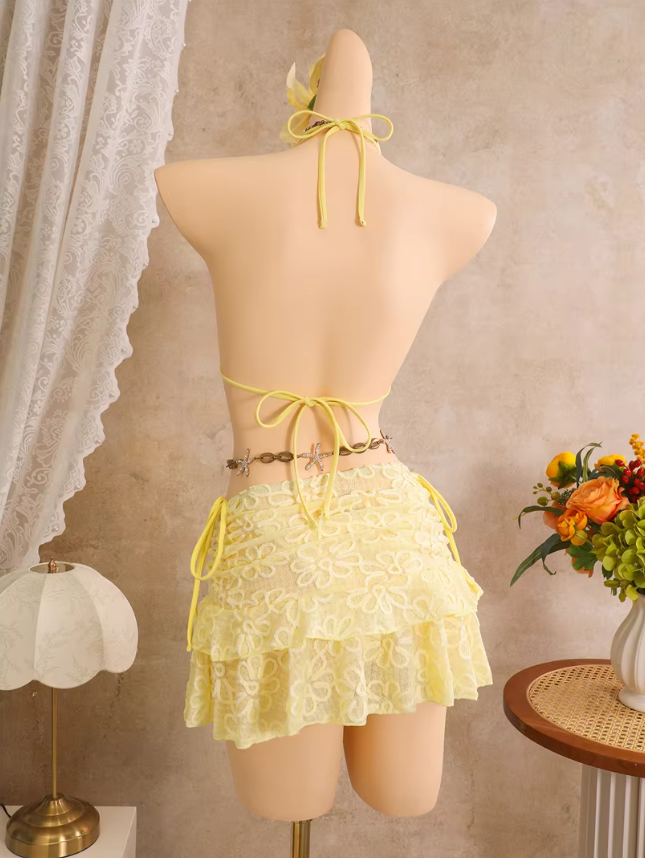 Back view of daffodil floral embroidered bikini and sheer mini skirt set with halter tie, back tie and side-tie skirt.