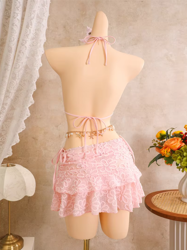 Back view of pink floral embroidered bikini and sheer mini skirt set with halter tie, back tie and layered skirt.