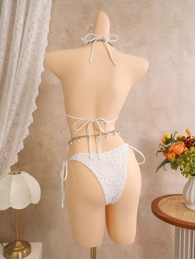 Back view of white floral embroidered bikini set with adjustable halter tie, back tie and cheeky tie-side bottoms.
