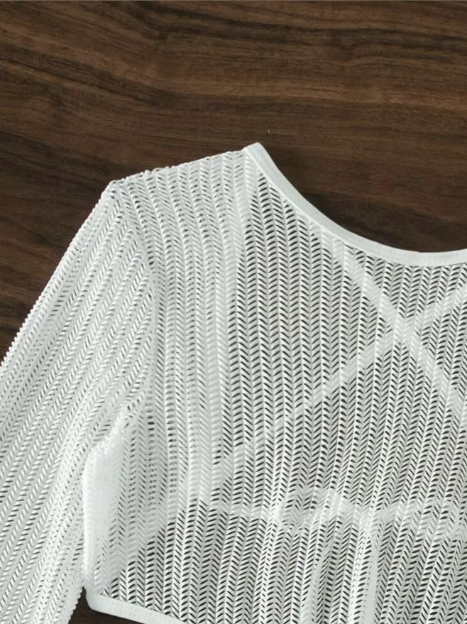Close-up view of the white sheer knit dress showing the open-knit texture and long-sleeve design.