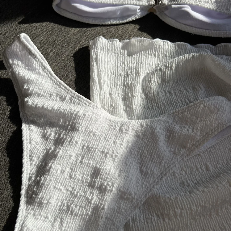 Close-up of Boracay white textured bikini bottoms and matching sarong fabric with raised crinkle finish.