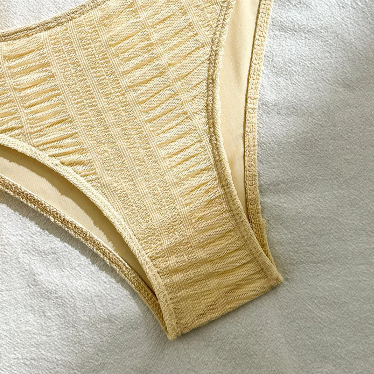 Close-up of ivory textured high-leg bikini bottoms with soft lining and textured stretch finish.