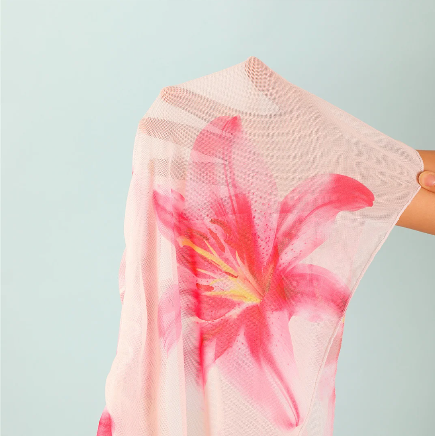 Close-up of Camellia sheer wrap skirt in white mesh with oversized pink lily floral print.