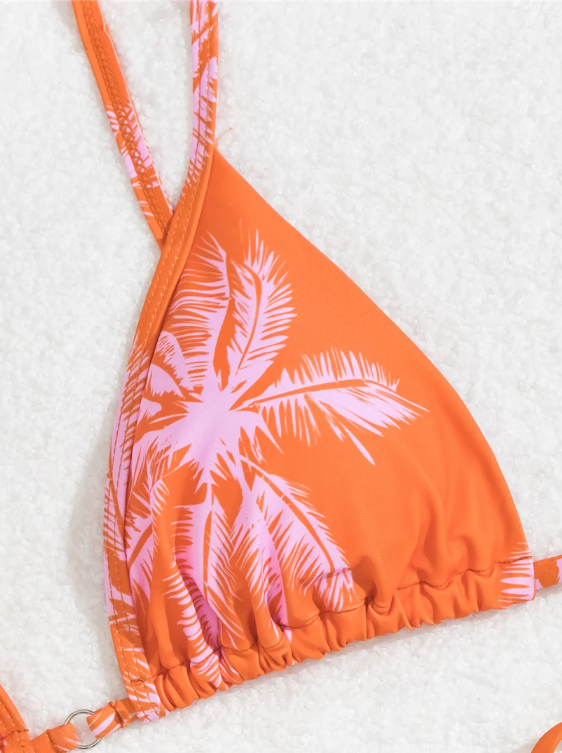 Close-up of orange palm print bikini fabric with triangle cup and soft pink palm motif.