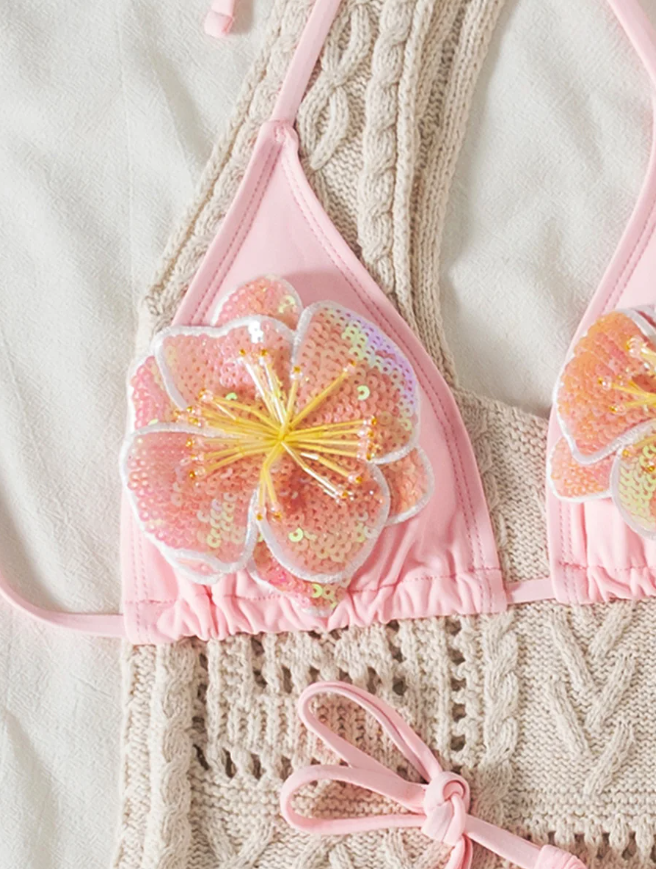 Close-up of Coral Bay pink triangle bikini top with sequin floral appliqué and adjustable halter ties.