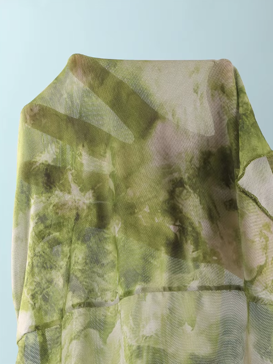 Close-up of CURATOR Collection Capri green marbled sheer mesh fabric with soft translucent resort finish.