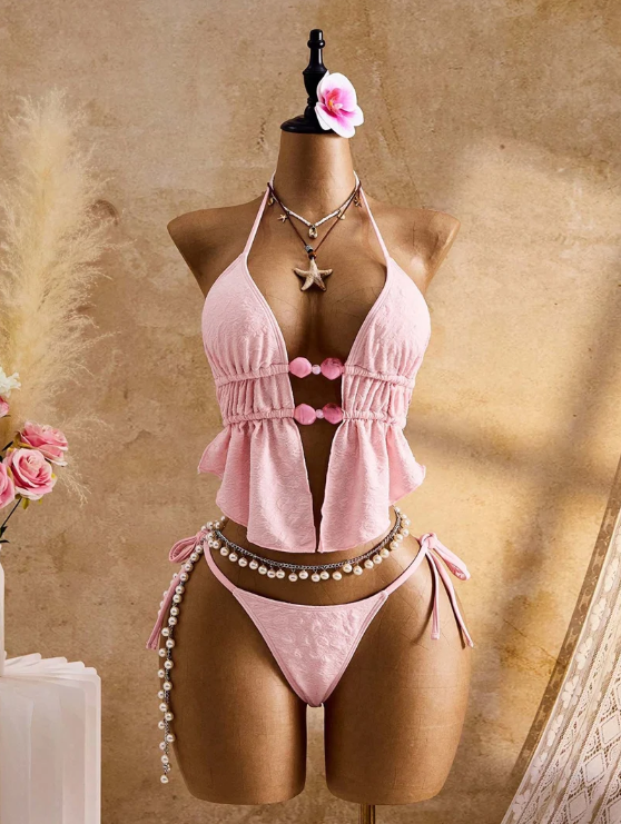 Front view of the CURATOR Collection Amara Set in camellia pink, featuring a halter peplum bikini top with bead front detail and matching tie-side bikini bottoms.