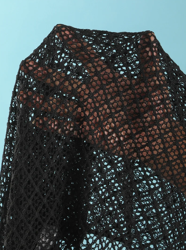 Close-up of black openwork crochet-look fabric with diamond texture and sheer resort finish.