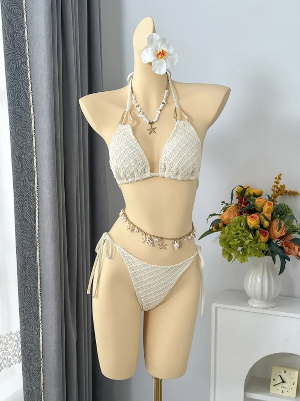 Ivory textured triangle halter bikini with tie-side bottoms displayed on mannequin.