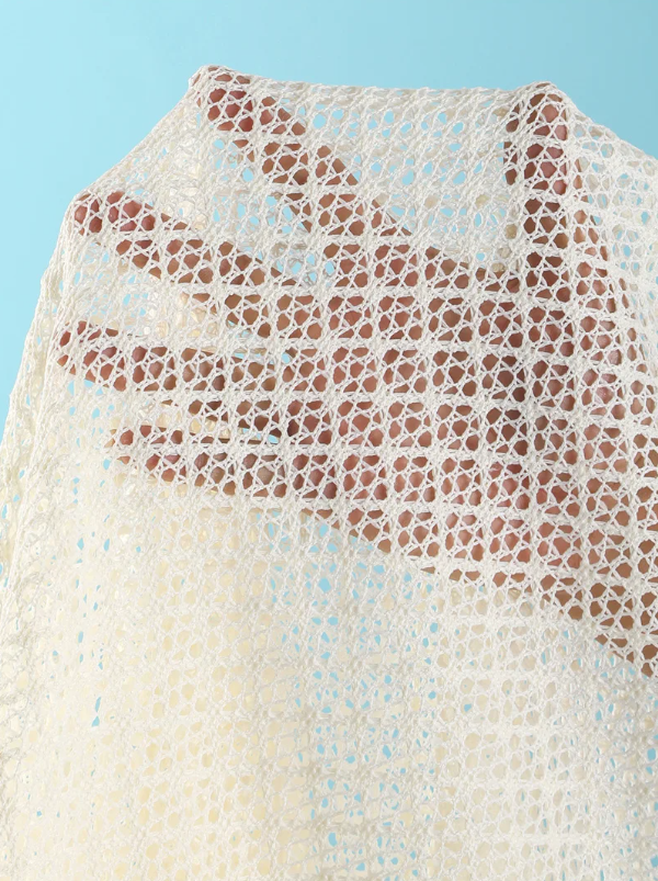 Close-up of ivory openwork crochet-look fabric with diamond texture and sheer resort finish.