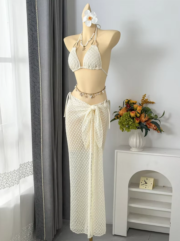 Angled front view of ivory textured halter bikini set with sheer openwork maxi sarong.