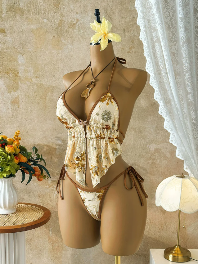 Angled front view of the CURATOR Collection Bijou Set in champagne, showing the embroidered mesh finish, plunging neckline and gathered peplum silhouette.
