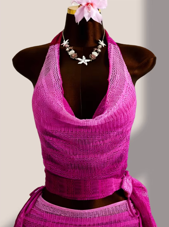 Close-up of the Orchid Estelle cover-up top with draped halter neckline and textured pink openwork finish.