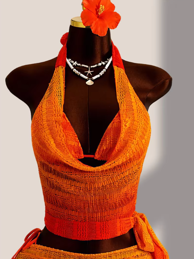 Close-up of the Saffron Estelle cover-up top with draped halter neckline and textured orange gradient finish.