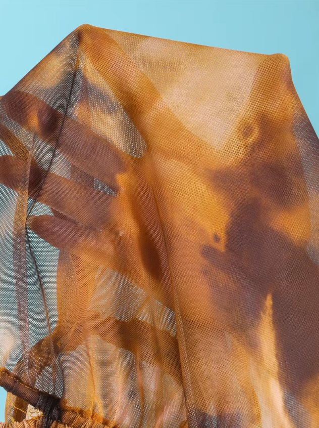 Close-up of the Moonstone sheer mesh fabric with warm amber and mocha tie-dye print.