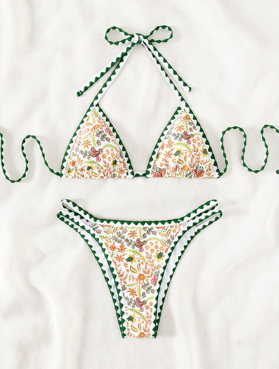 Dominica white botanical floral bikini set flat lay with triangle top and high-leg bottoms.