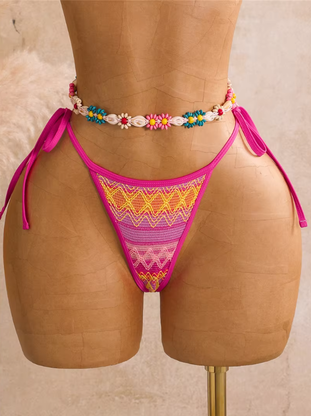 Close-up of flamingo pink textured tie-side bikini bottoms with zigzag pattern and bright pink binding.