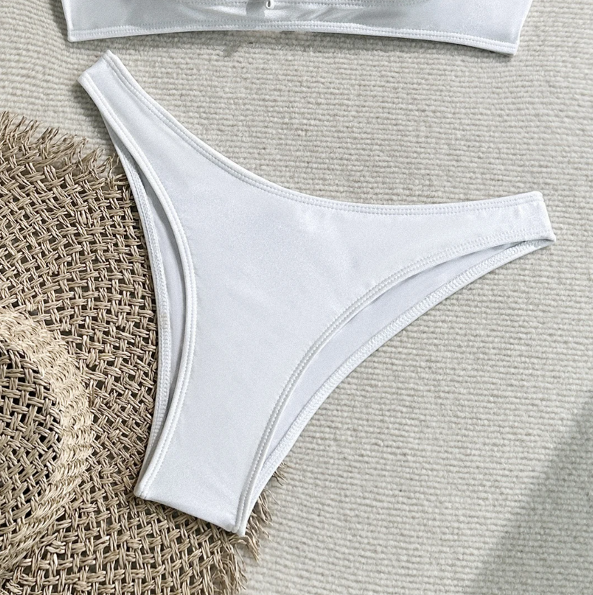 Close-up of white high-leg bikini bottoms with smooth stretch fabric and clean seam detailing.