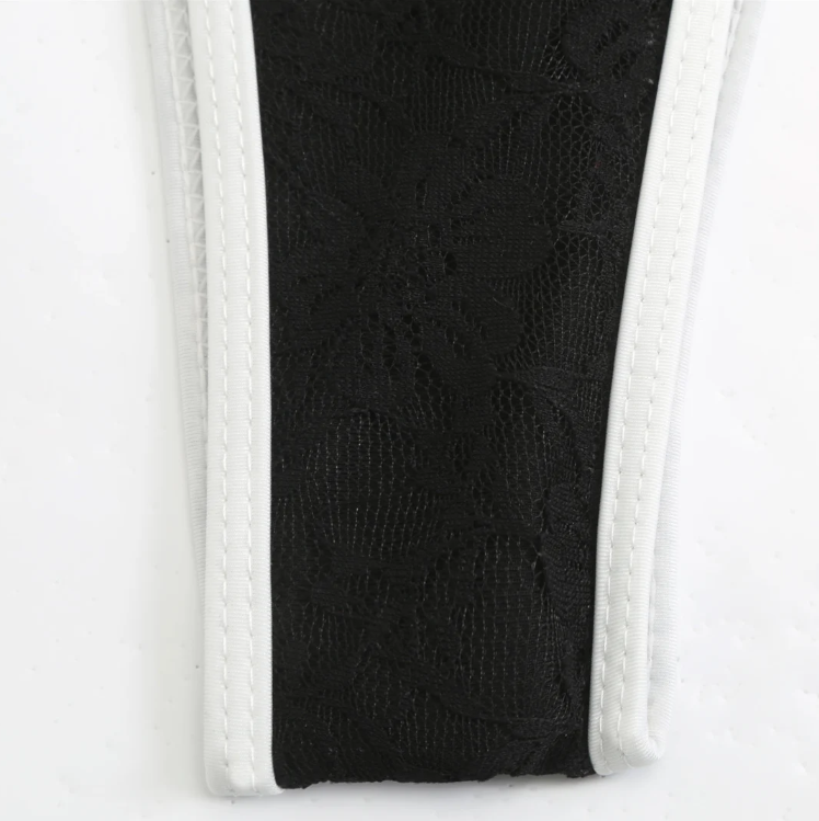 Close-up detail of the Grenada Bikini & Skirt Set in black, highlighting the floral lace fabric with contrast white trim.