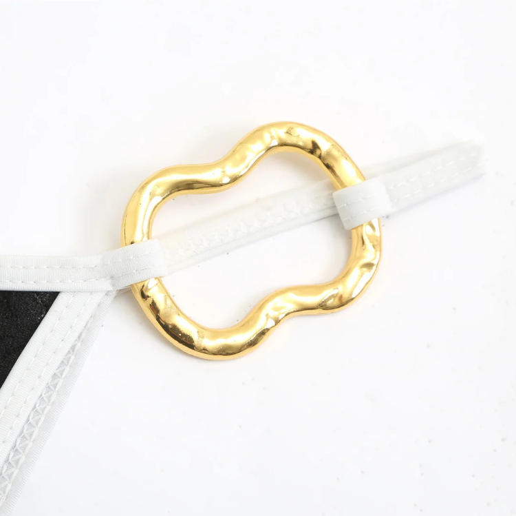 Close-up detail of the Grenada Bikini & Skirt Set, highlighting the gold ring hardware and contrast white strap detail.
