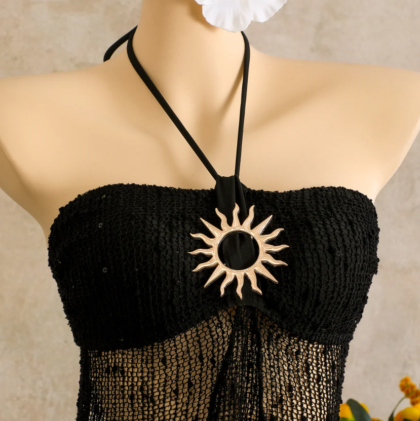 Black sheer openwork halter dress with gold-tone sun hardware and textured bust detail.