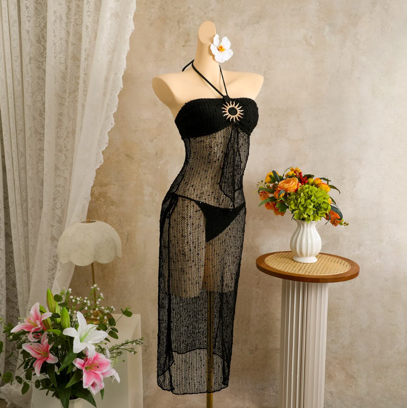 Black sheer halter maxi dress set with gold-tone sun hardware displayed on mannequin.