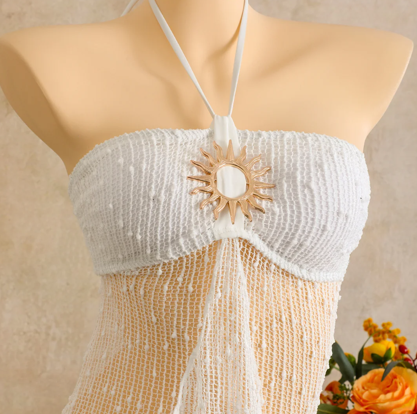 Close-up of ivory halter dress with textured bust panel and gold-tone sun centre hardware.