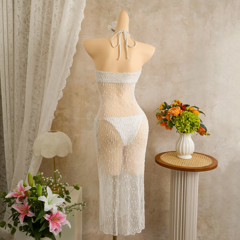 Back mannequin view of ivory sheer halter maxi dress with tie neck and openwork finish.