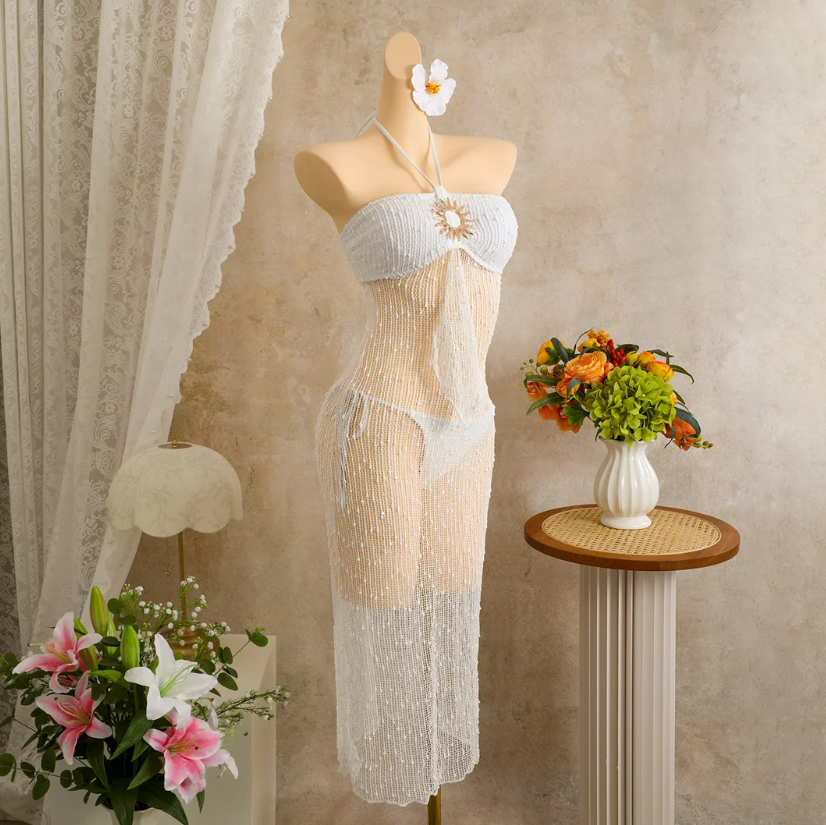 Angled mannequin view of ivory sheer openwork halter dress set with sculptural sun hardware.