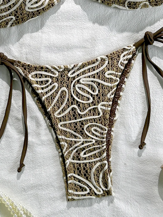 Close-up of brown crochet-look tie-side bikini bottoms with cream cord embroidery and dark brown side ties.