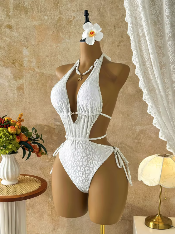 Angled front view of white tonal leopard one-piece swimsuit with halter neckline, sculpted waist cut-outs and tie-side detailing.