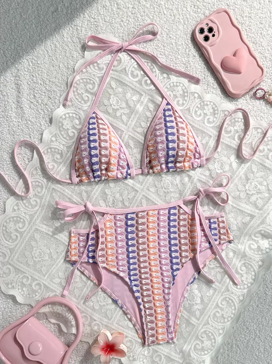 Pastel crochet-look triangle bikini set with pink binding and high-waisted tie-side bottoms in a flat lay.