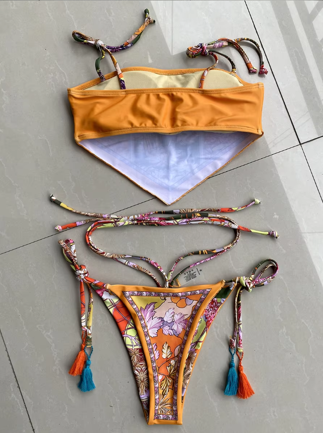 Back flat lay of Madeira bikini set showing orange bandeau lining, printed tie straps and matching tassel bikini bottoms.