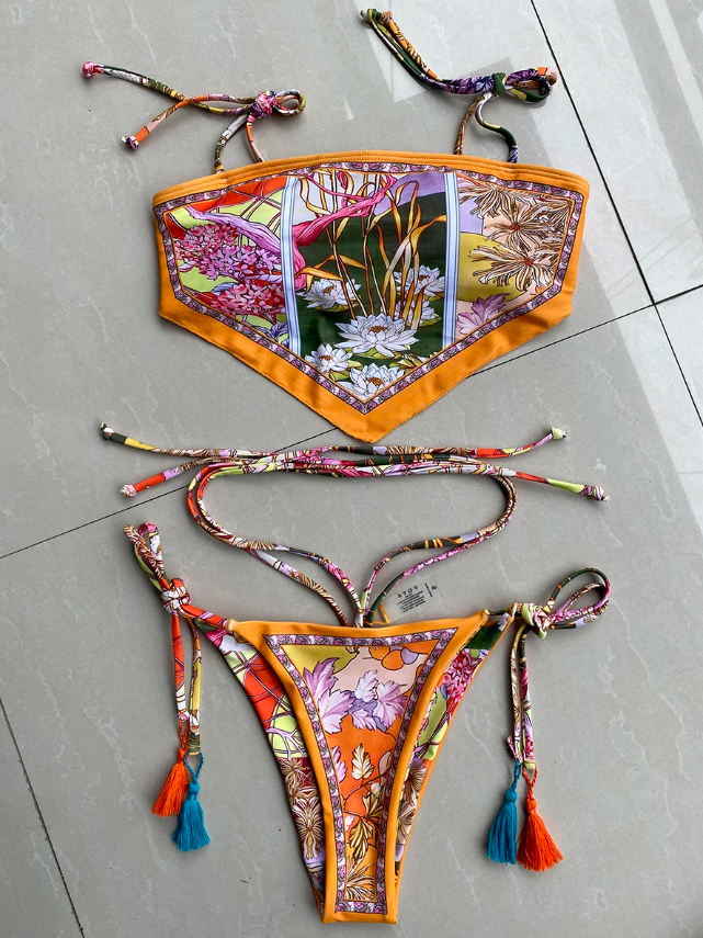 Flat lay of Madeira bikini set with botanical scarf-print bandeau top, matching tie-side bottoms and tassel accents.