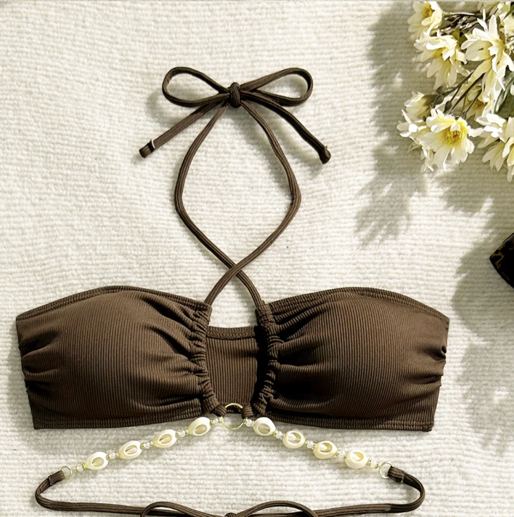 Close-up of chocolate brown ribbed bandeau bikini top with halter straps, gathered centre front and shell bead detailing.