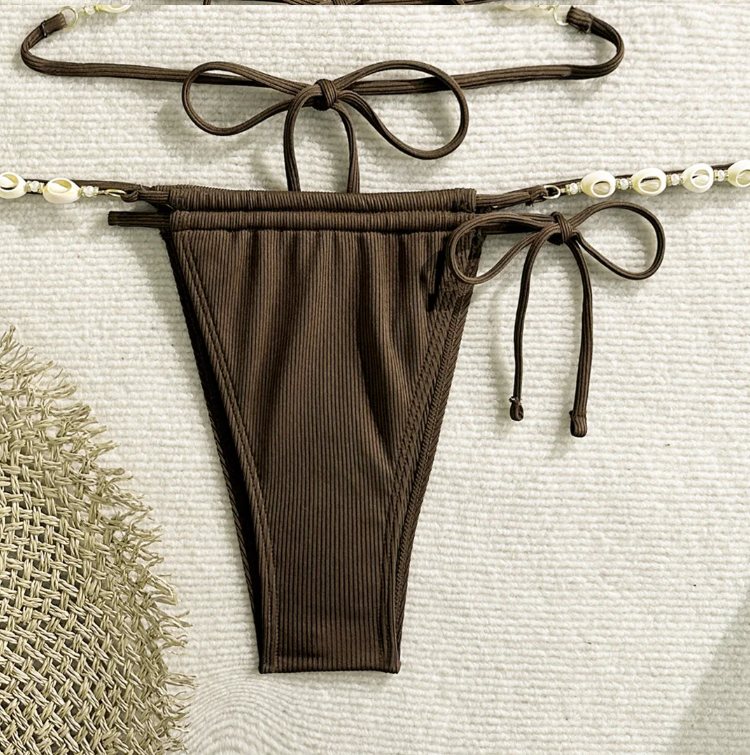 Close-up of chocolate brown ribbed string bikini bottoms with shell bead side detailing and tie fastening.