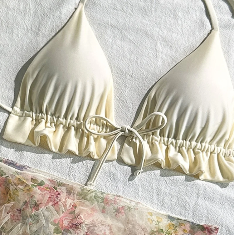 Close-up of the Malibu ivory triangle bikini top with soft cups, ruffle hem and centre tie detail.