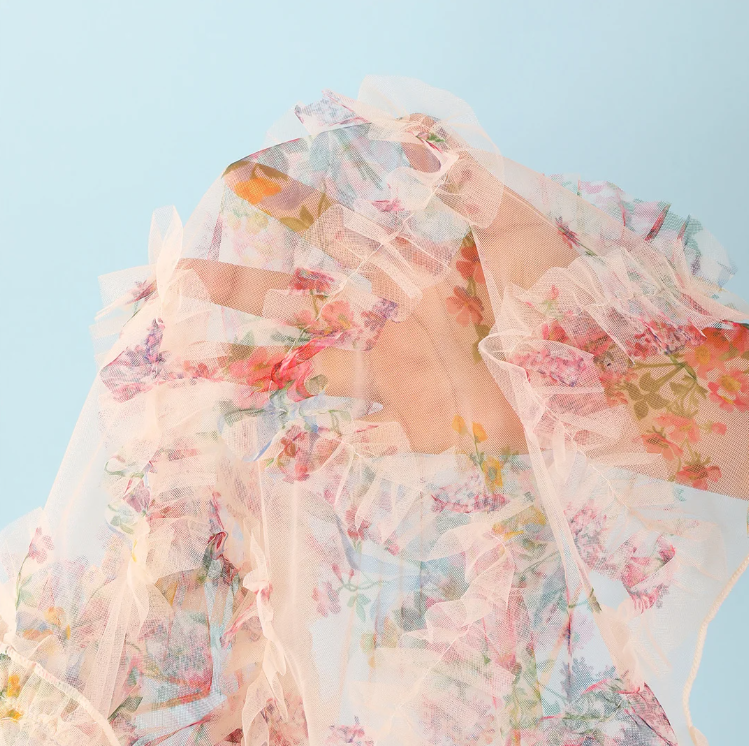 Close-up fabric detail of the Malibu sheer floral sarong with soft mesh texture and ruffled edges.