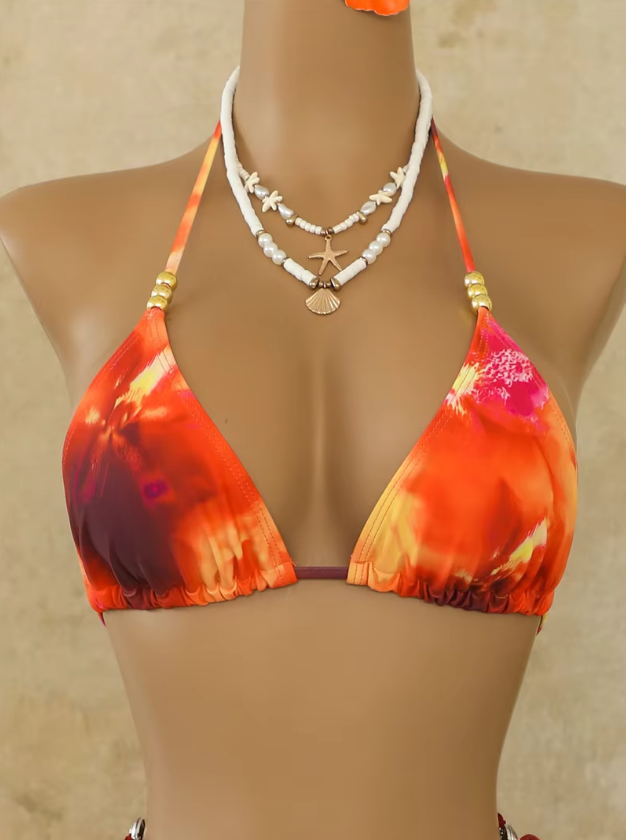 Close-up of Marbella orange triangle bikini top with sunset-inspired print and beaded halter straps.