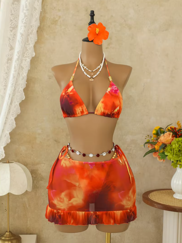 Marbella orange bikini and skirt set worn by model with triangle halter top, tie-side mini skirt and ruffle hem.