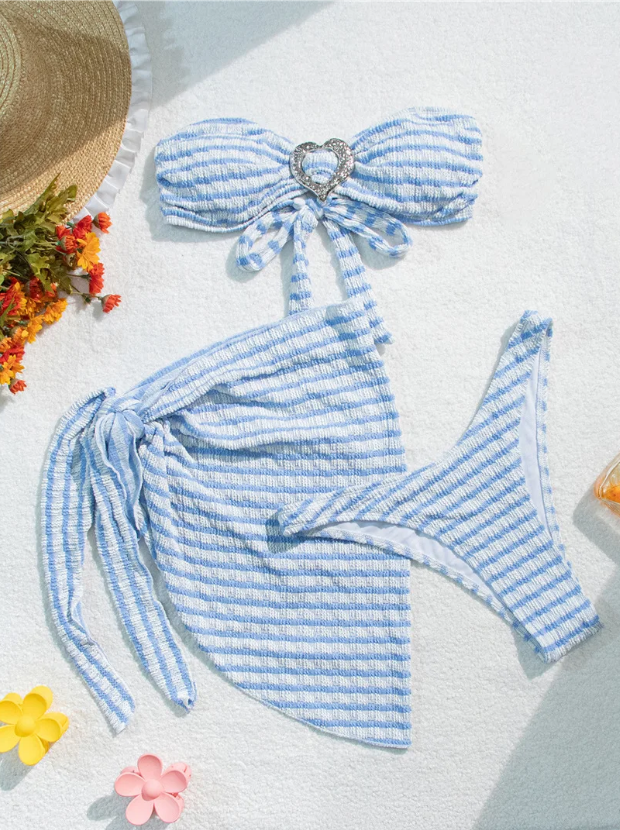 Flat lay of Marina blue and white striped bikini and sarong set with bandeau top, high-cut bottoms and matching wrap sarong.