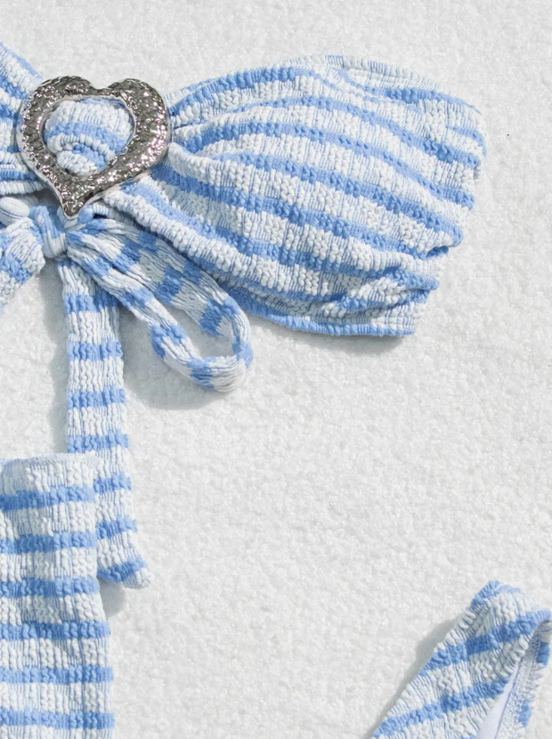 Close-up of Marina blue and white striped bandeau bikini top with textured fabric, centre tie and silver heart detail.