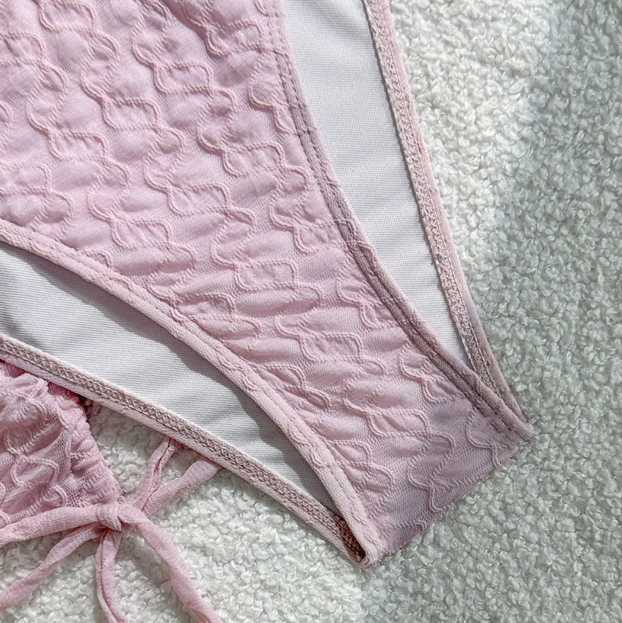 Close-up of Maya pink textured high-leg bikini bottoms with smooth lining and matching skirt ties.